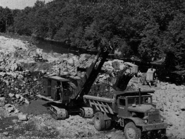 Machinery loading dumpster truck in the early stages of construction at Blake Falls in Parishville