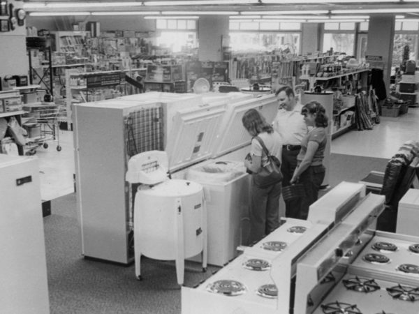 Western Auto Store salesman helps customers