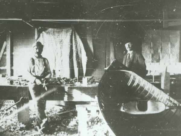 Two men inside the Palmer Boat Shop in the Adirondacks