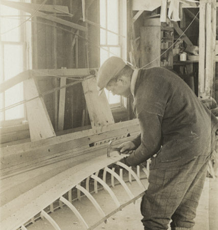 Wallace Emerson nails cladding onto boat in Long Lake