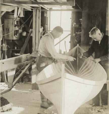 Emerson and worker assemble boat in boat shop in Long Lake