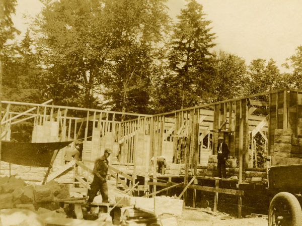 Men stand on scaffolding while building the Big Moose Chapel in the Town of Webb