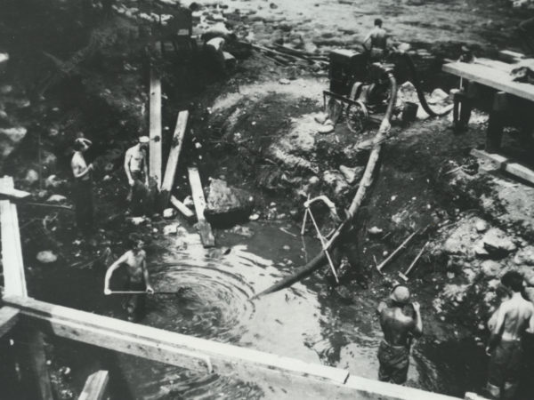 CCC workers use pump to drain pool