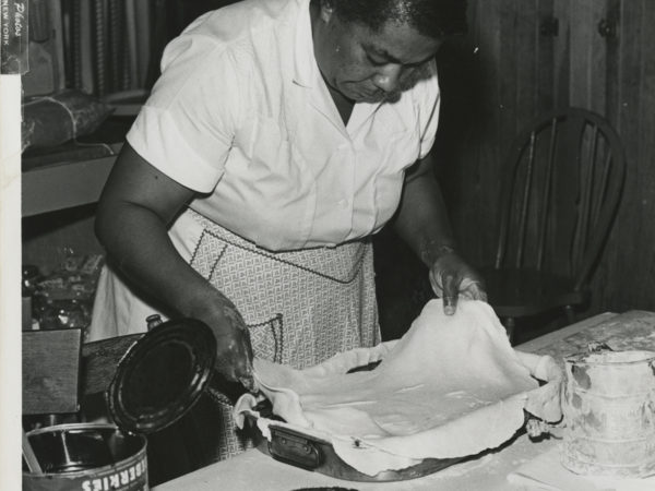 Cook lines baking pan with dough at the Echo Camp for Girls in Raquette Lake