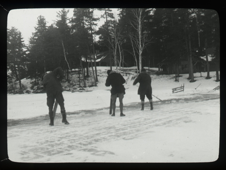 Men cut ice from frozen lake in the Adirondacks