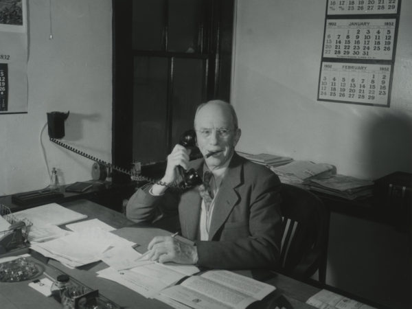 Arthur Owens answers the phone in the office of the Emporium Lumber Company in Conifer