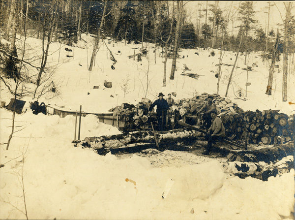 Men cut logs with a crosscut saw during the winter in Big Moose