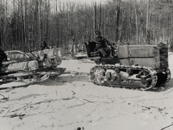 Log sled being pulled by tractor at CCC camp in Speculator