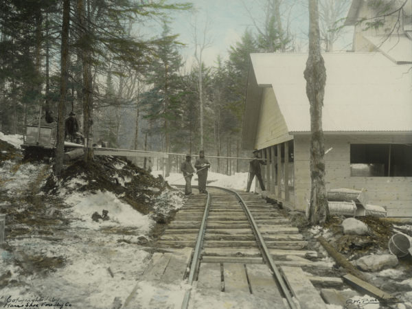 Men unload maple sap from bobsled into Horseshoe Forestry Company sugarhouse in Piercefield