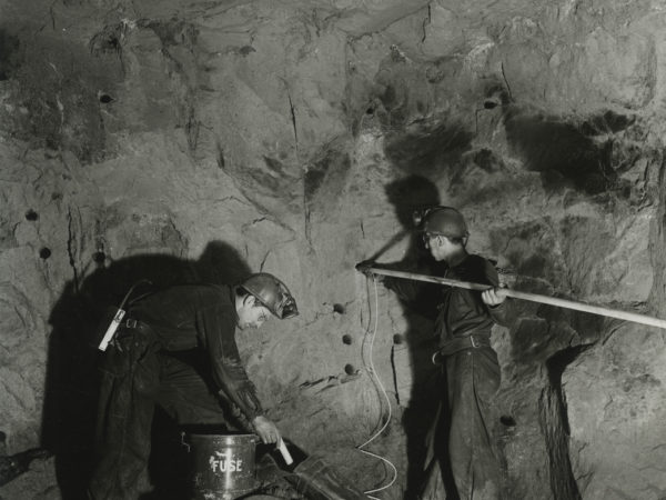 Men load a drift heading with explosives in a mineshaft in Mineville