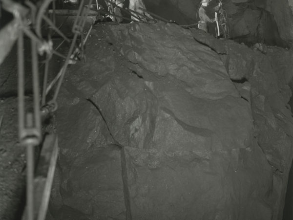 Miners working on a ledge inside a shaft in Mineville