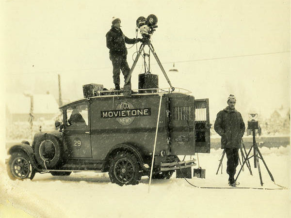 Man operates motion picture camera atop a Fox News truck in Saranac Lake