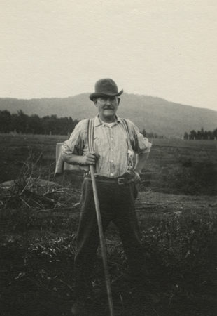 Mr. Wood poses with handtool in his farm field in North Elba