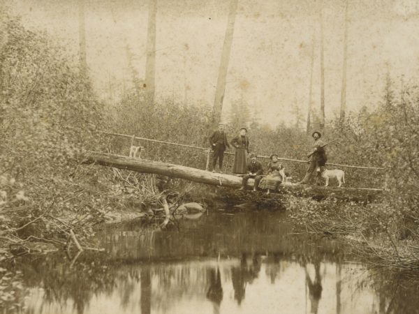 Guides and tourists on a log bridge in Paul Smiths