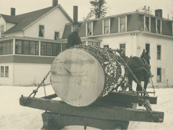 Man with large log on bob sled at Paul Smith’s Hotel in Paul Smiths