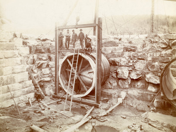 Workers posed with a flume pipes in the Spier Falls Dam