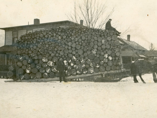 A large load of pulpwood in front of the Spread Eagle Inn in Keene Valley