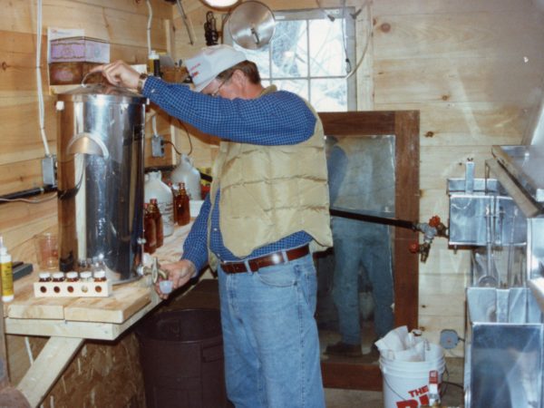 George Jacques drawing off syrup in Keene Valley