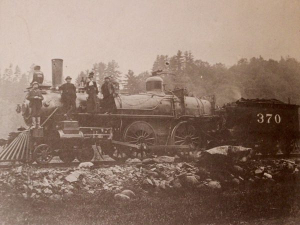 Railroad workers atop an engine in North Creek