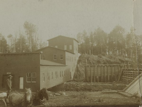 Man on a horse-driven wagon outside the graphite mill in Johnsburg