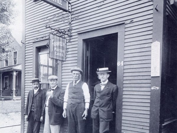 Four men outside Green’s Market in Saranac Lake