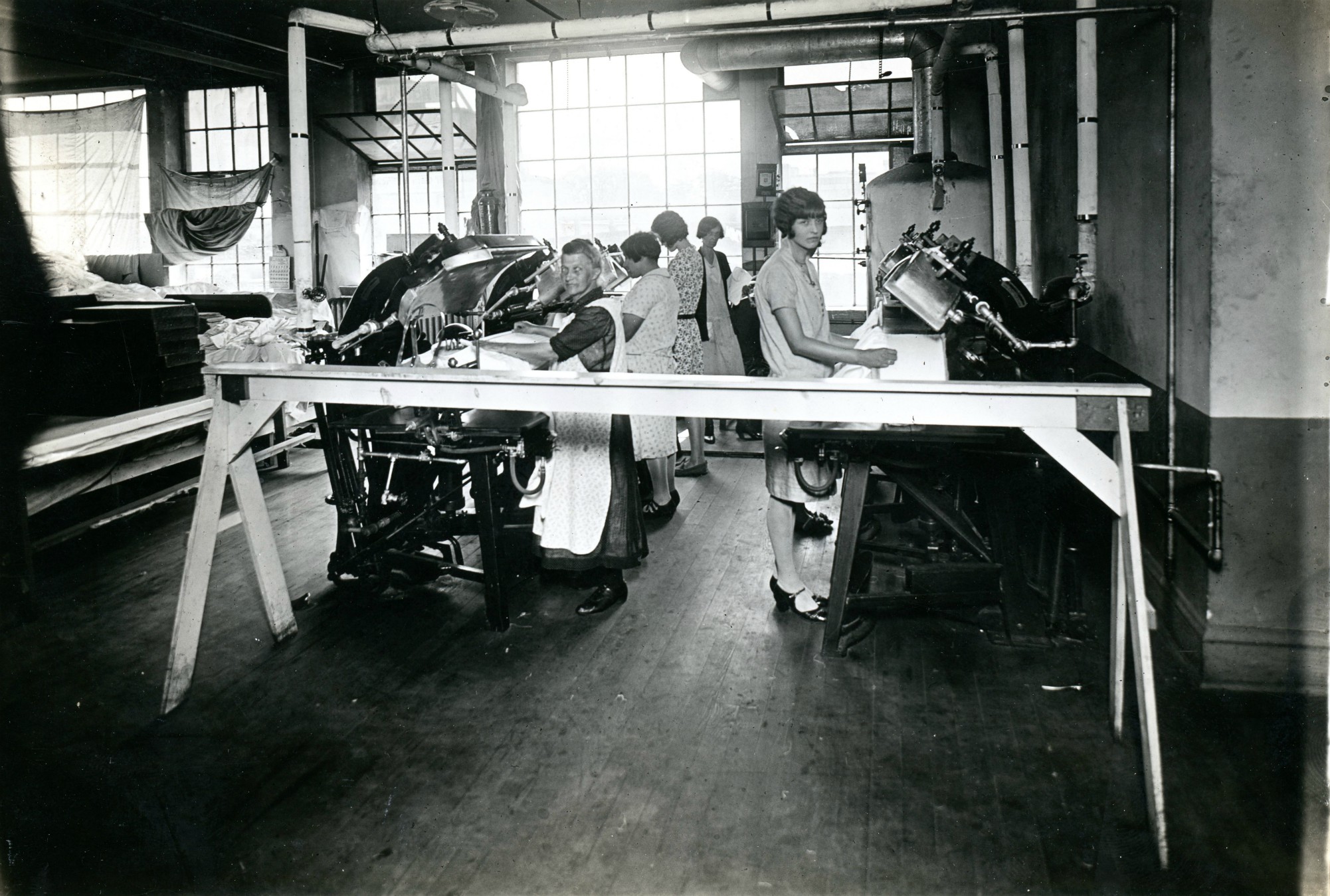 Workers using machines at the Geo Sweetser & Son Shirt Factory in