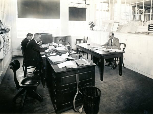 : Men in the offices of the Geo Sweetser & Son Shirt Factory in Watertown