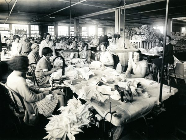 Workers among piles of shirts at the Geo Sweetser & Son Shirt Factory in Watertown