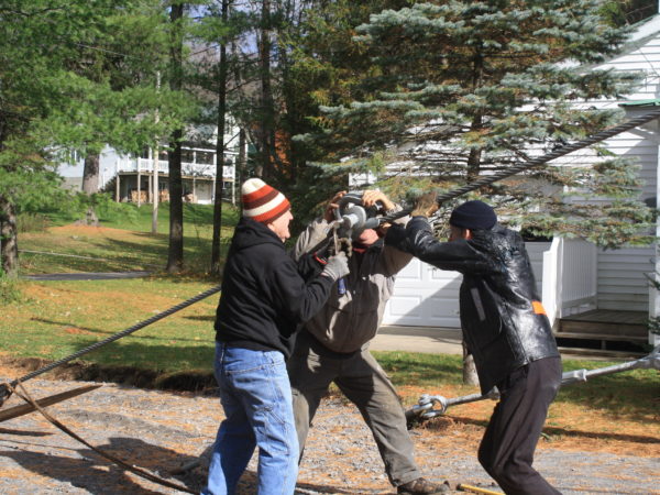 Three men stringing cable for the Wanakena footbridge