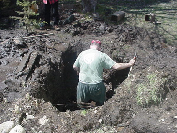 Volunteer fixing a break in the water system in Wanakena