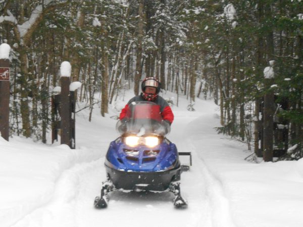 Grooming trails with a snowmobile at Catamount Forest in Colton