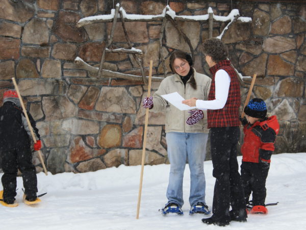 Ruth McWiliams teaching a family to snowshoe in Colton