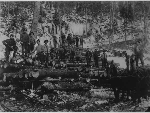 A group of lumberjacks with logs in Tupper Lake