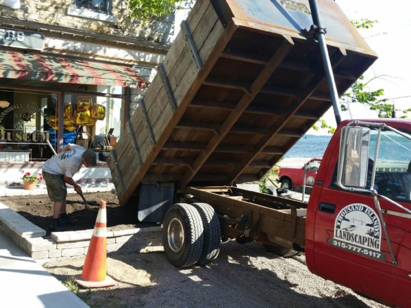 A Thousand Islands Landscaping truck dumping dirt in Alexandria Bay