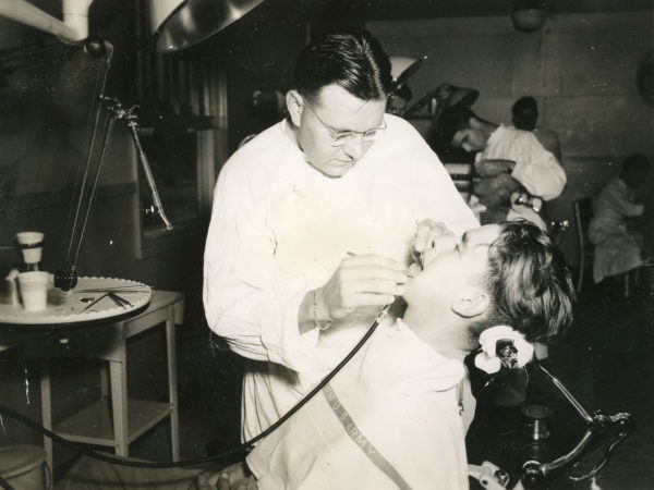 Military dentist Arthur Hewett working on a soldier at Pine Camp