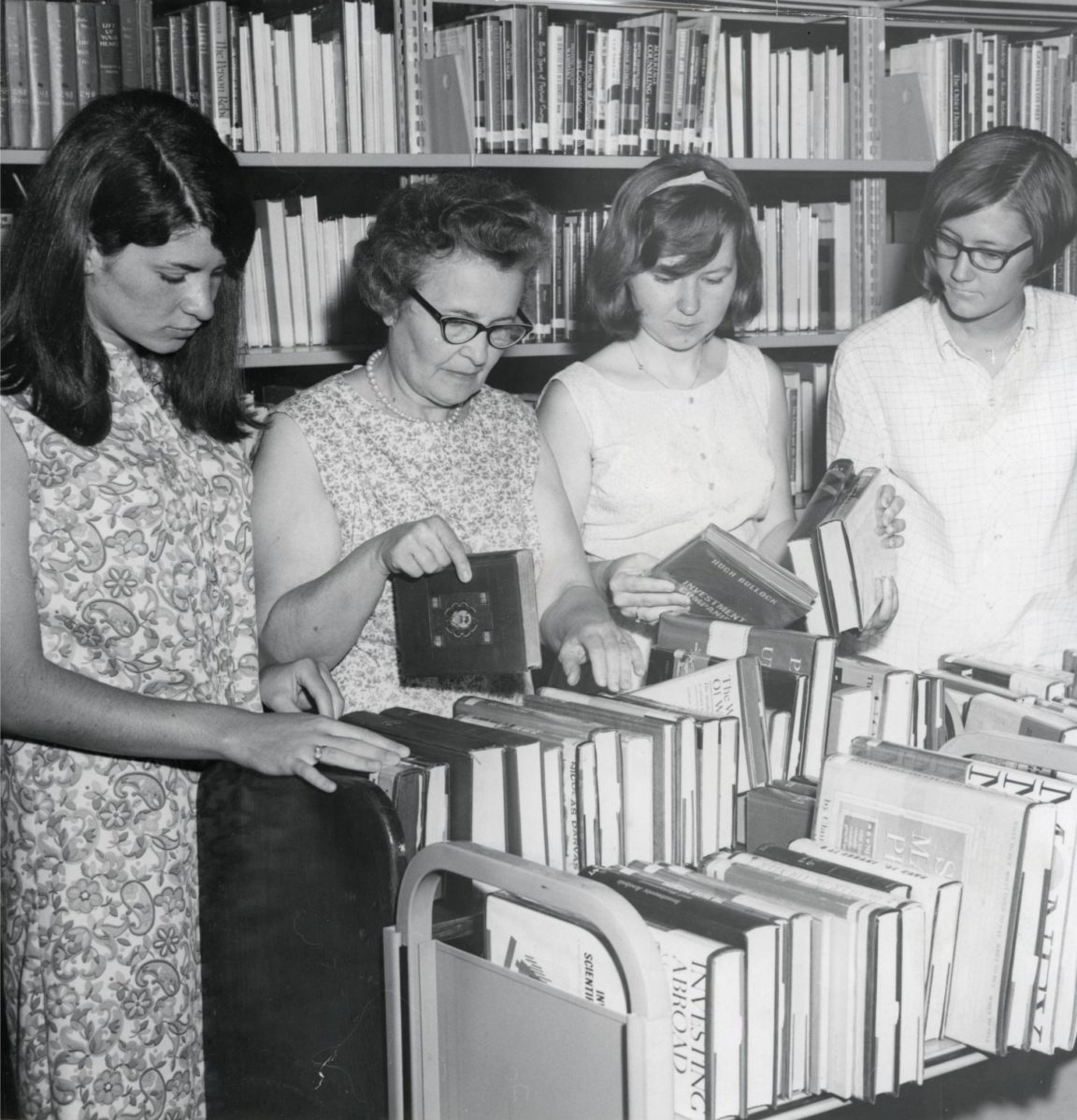 Library staff look over book cart at Crandall Public Library in Glens