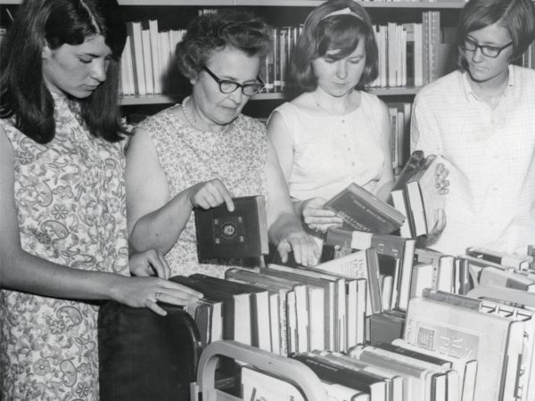 Library staff look over book cart at Crandall Public Library in Glens Falls