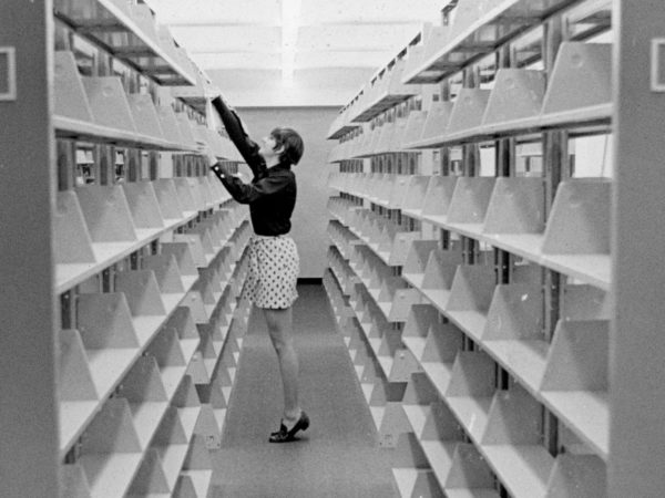 Library page dusts empty bookshelves in new wing at Crandall Public Library