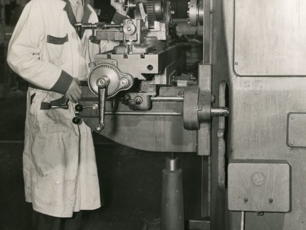 Man operating a lathe at the National Defense Aviation School in Glens Falls