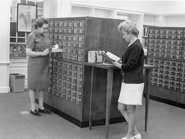 Reference Librarian and patron look through the card catalog at Crandall Public Library in Glens Falls