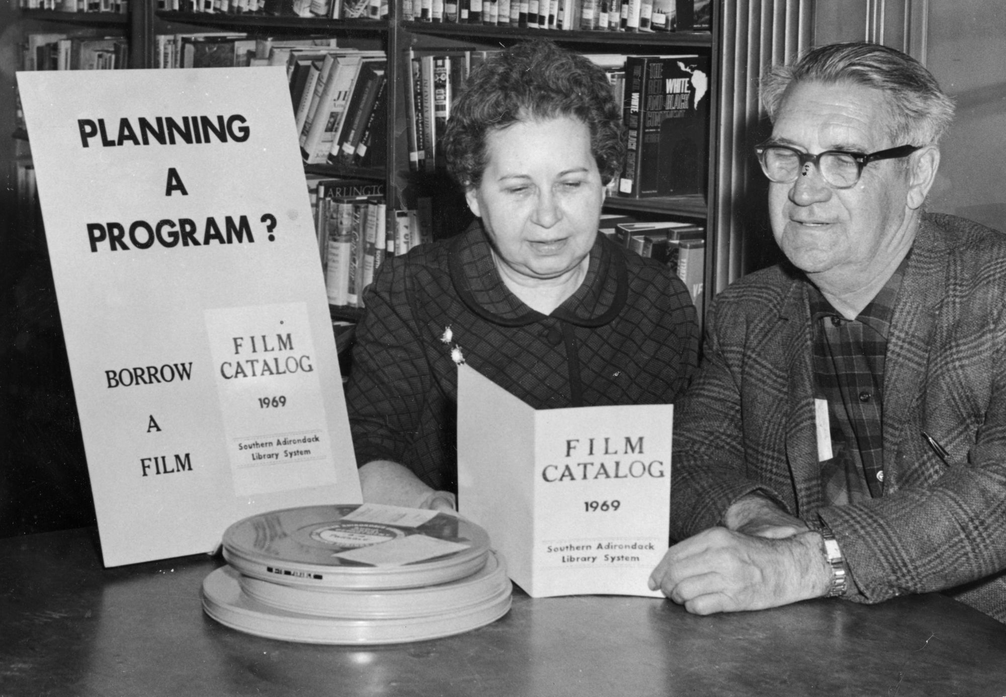 Librarian McAndrews Shows Film Catalog To A Patron At The Crandall Librarian McAndrews Shows Film Catalog To A Patron At The Crandall