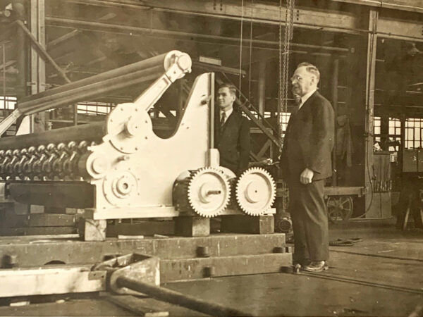 Draftsman Frans Alfred Helin (right) inspects machine at the Bagley & Sewall Company