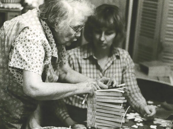 Woman demonstrates basket making technique