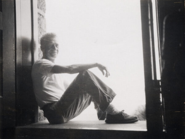 Gerald Heath sits in doorway or windowsill