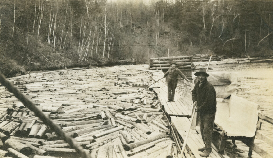 Men on floating dock during log drive in Au Sable Forks