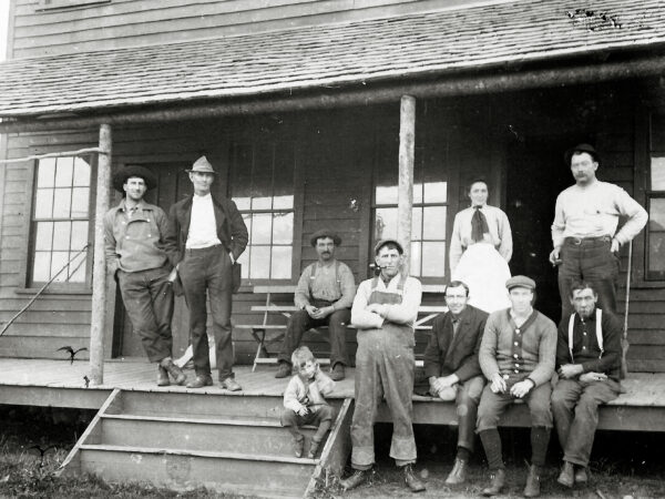 Guides sit and stand on the porch of a guide house