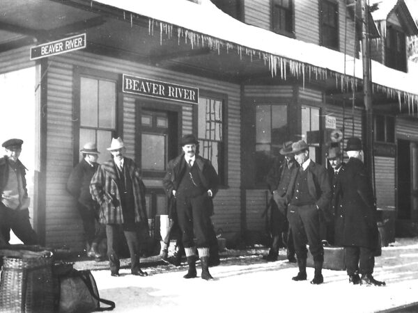 Men stand outside the Beaver River Train station in winter