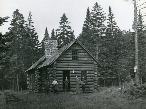 Forest rangers at log cabin