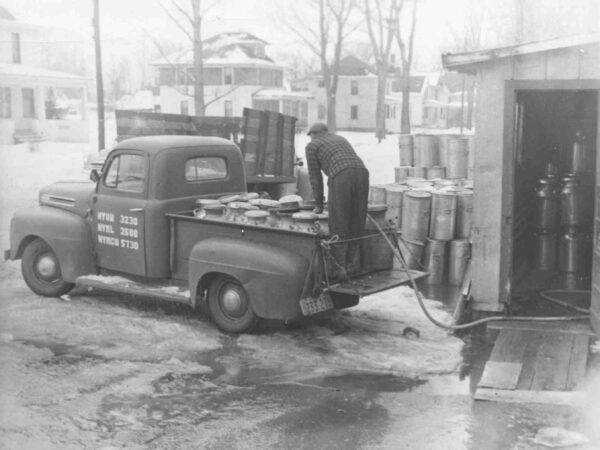 Farmer emptying milk cans